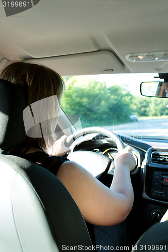 Image of Young woman driving the car