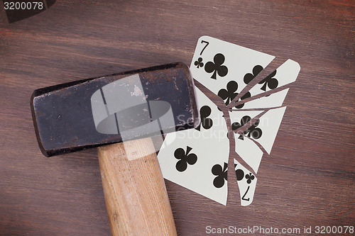 Image of Hammer with a broken card, seven of clubs