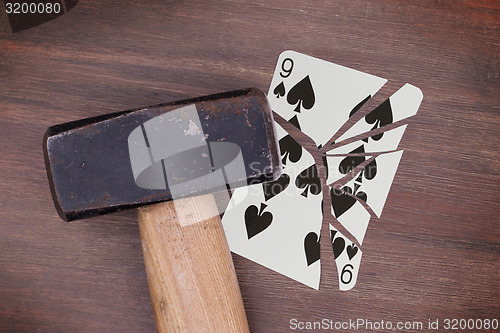 Image of Hammer with a broken card, nine of spades