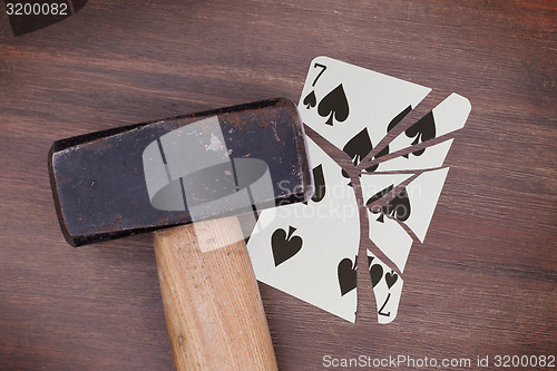 Image of Hammer with a broken card, seven of spades