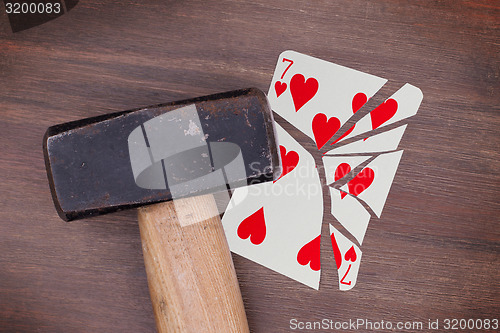 Image of Hammer with a broken card, seven of hearts