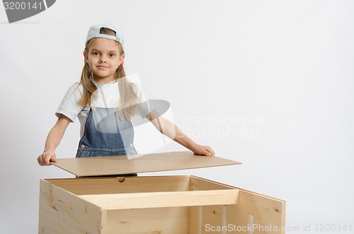 Image of Girl collects the back cover of chest