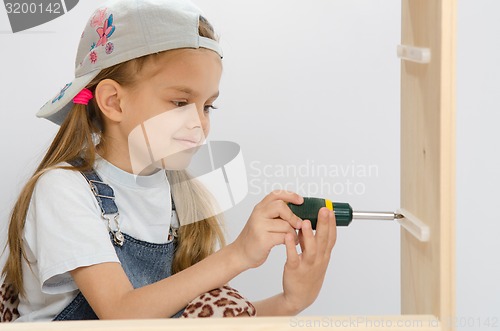 Image of Child screwed fastening wooden cabinet