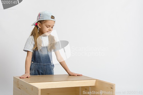 Image of child looks at the result of assembling furniture