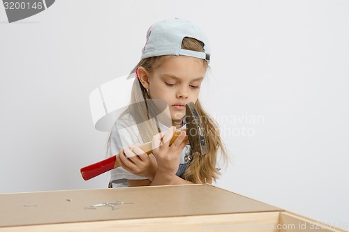 Image of Girl holding a hammer wrong