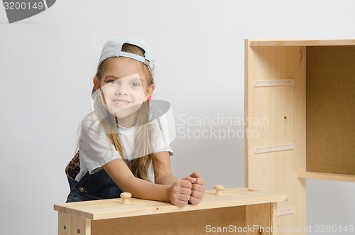 Image of Girl sitting with an assembled frame and chest wooden box