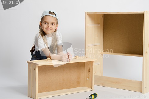 Image of The child sits with a skeleton chest and box