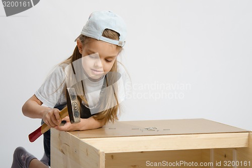 Image of Girl in classroom work to hammer nail with a hammer