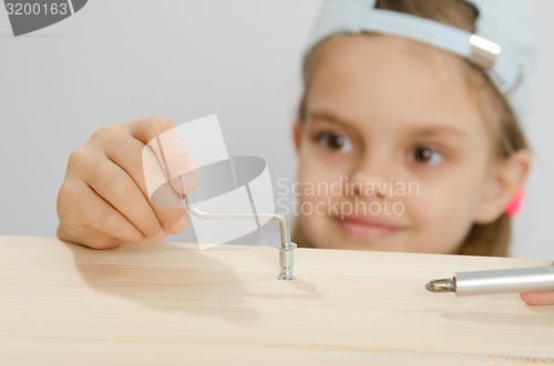 Image of Girl in the classroom working spins screw