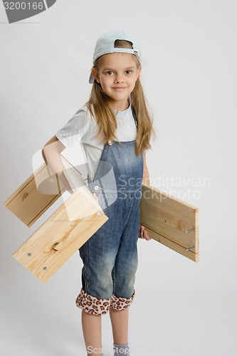 Image of Portrait of a six year old girl with boards in hands
