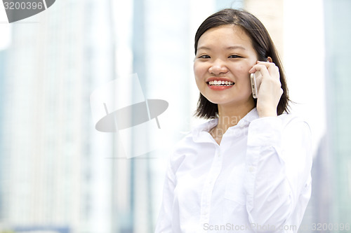Image of Asian young female executive talking on smart phone