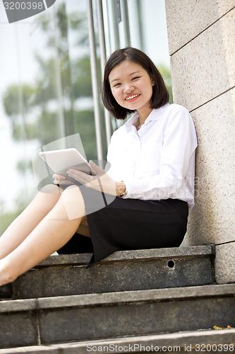 Image of Asian young female executive using tablet