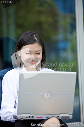 Image of Asian young female executive using laptop