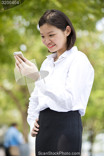 Image of Asian young female executive looking at smart phone