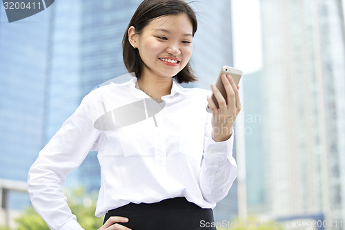 Image of Asian young female executive looking at smart phone