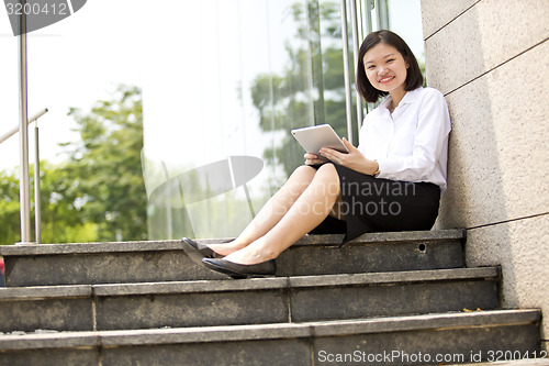 Image of Asian young female executive using tablet