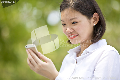 Image of Asian young female executive looking at smart phone