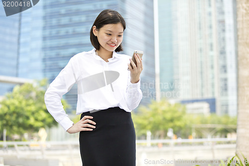 Image of Asian young female executive looking at smart phone