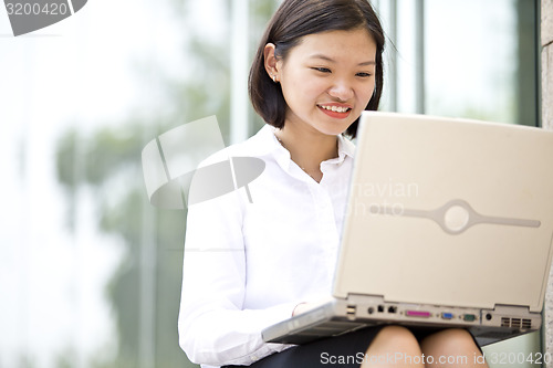 Image of Asian young female executive using laptop