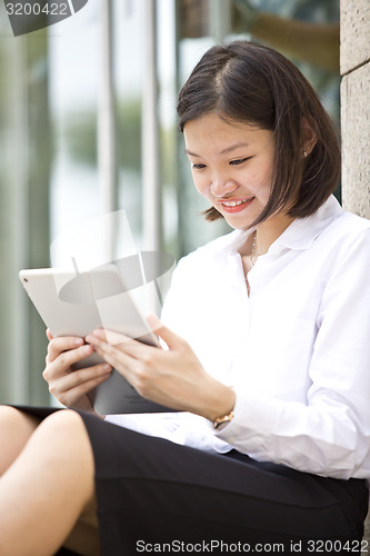 Image of Asian young female executive using tablet