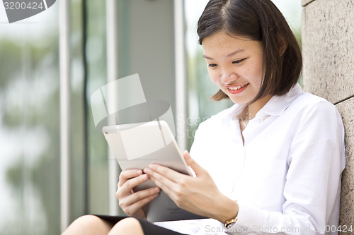 Image of Asian young female executive using tablet