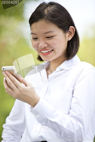 Image of Asian young female executive looking at smart phone