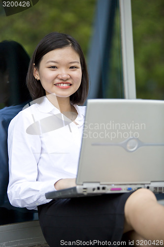 Image of Asian young female executive using laptop