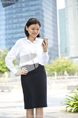 Image of Asian young female executive looking at smart phone