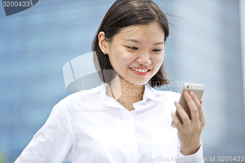 Image of Asian young female executive looking at smart phone