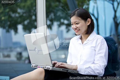 Image of Asian young female executive using laptop