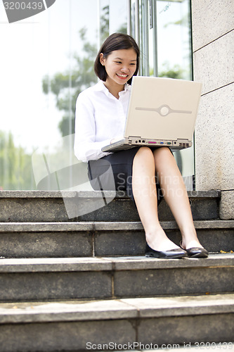 Image of Asian young female executive using laptop