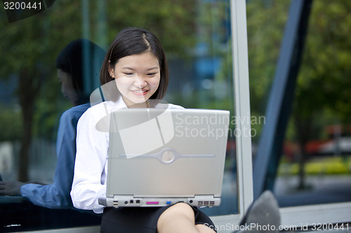 Image of Asian young female executive using laptop