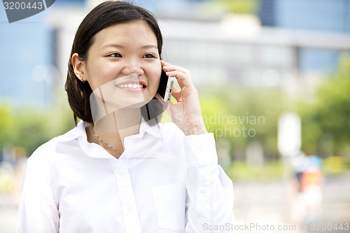 Image of Asian young female executive talking on smart phone