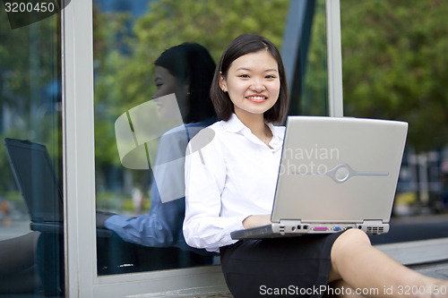 Image of Asian young female executive using laptop
