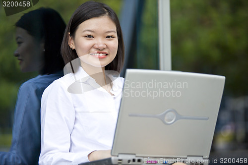 Image of Asian young female executive using laptop