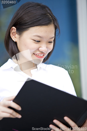 Image of Asian young female executive holding file smiling