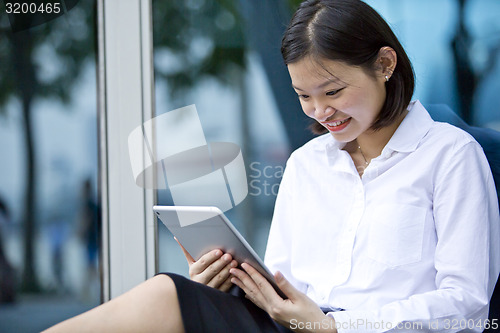 Image of Asian young female executive using tablet