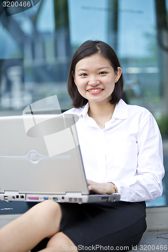 Image of Asian young female executive using laptop