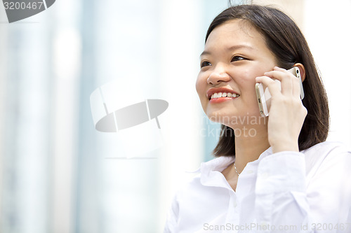 Image of Asian young female executive talking on smart phone