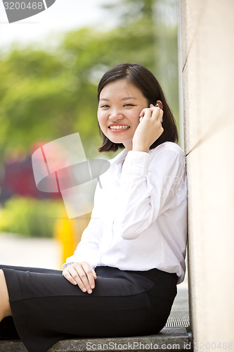 Image of Asian young female executive talking on smart phone