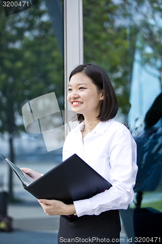 Image of Asian young female executive holding file smiling