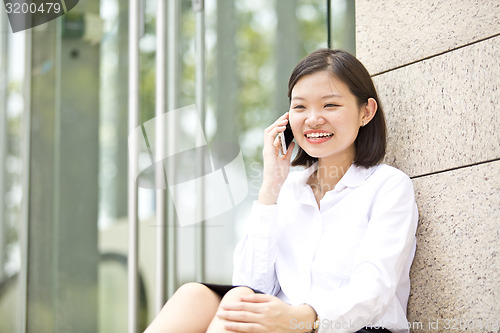 Image of Asian young female executive talking on smart phone