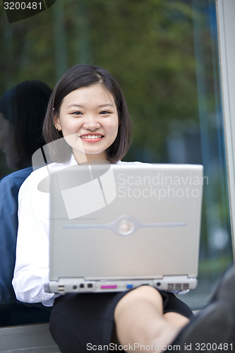 Image of Asian young female executive using laptop