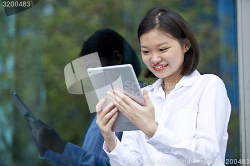 Image of Asian young female executive using tablet