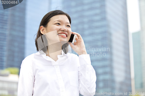 Image of Asian young female executive talking on smart phone
