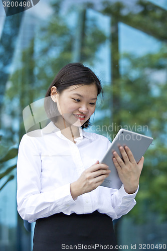 Image of Asian young female executive using tablet