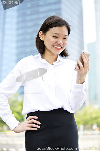 Image of Asian young female executive looking at smart phone