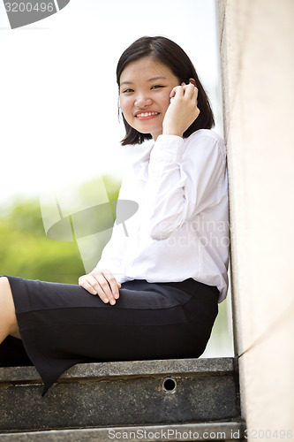 Image of Asian young female executive talking on smart phone