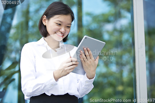 Image of Asian young female executive using tablet