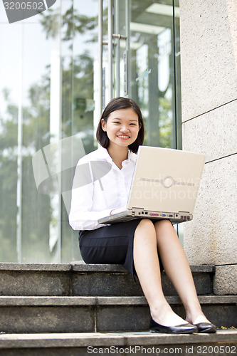 Image of Asian young female executive using laptop
